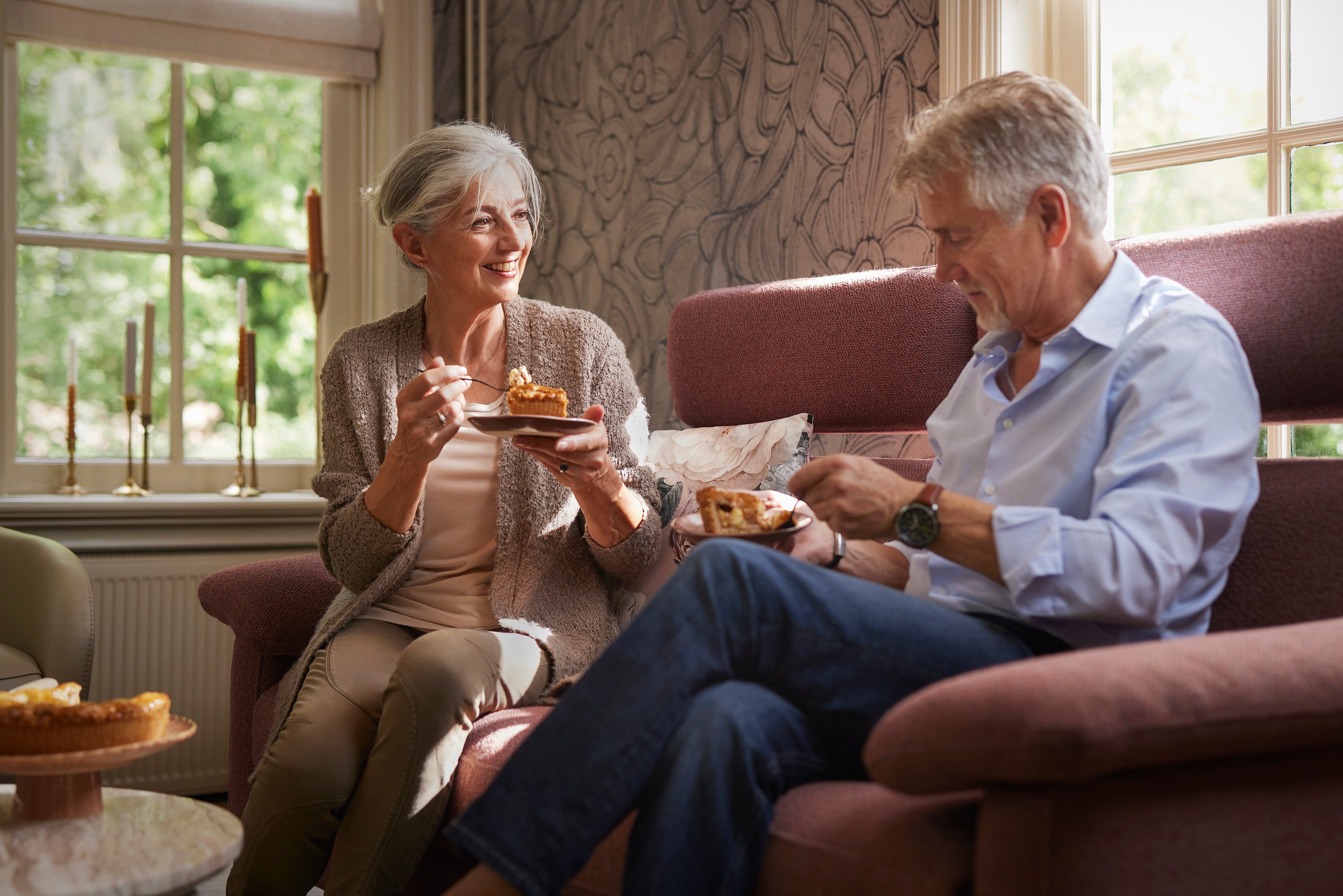 Meneer en mevrouw eten appeltaart op bank Riva